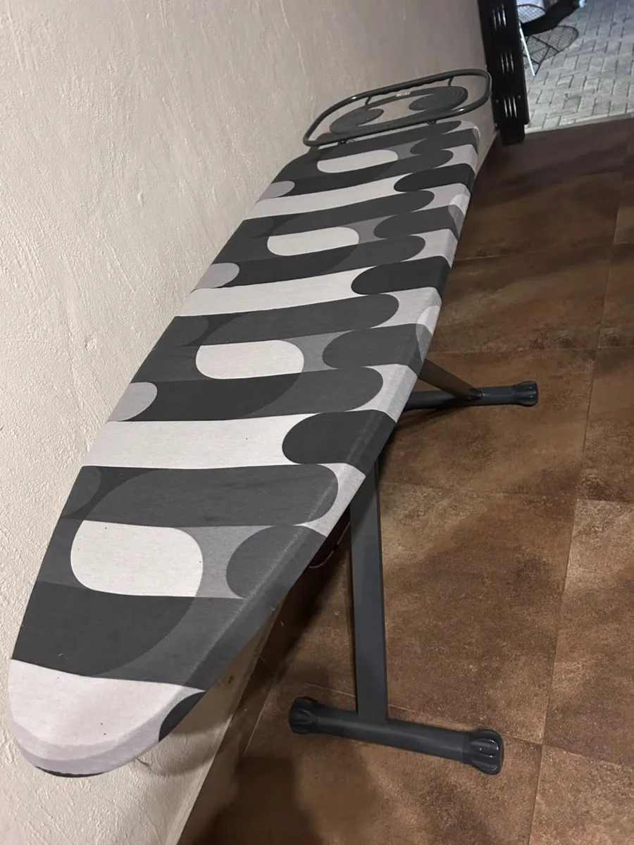 The household’s ironing board with its black-and-white patterned cover.